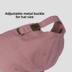 Detailed macro view of the adjustable bronze metal buckle on a cotton baseball cap