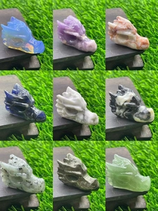 Collection of nine colorful 1.5-inch natural stone dragon head carvings on a wood display