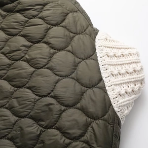 Close-up of olive green quilted fabric joined with cream cable knit cuffs and textures
