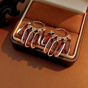Détail de créoles dorées vintage avec pendentifs en verre ambre dans un coffret cadeau en velours