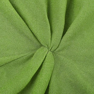 Détail du tissu scintillant vert de la robe à épaules dénudées avec nœud central et plis fins