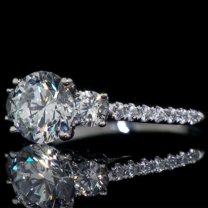 Elegant three-stone zircon ring with round brilliant cut and micro-pave diamonds