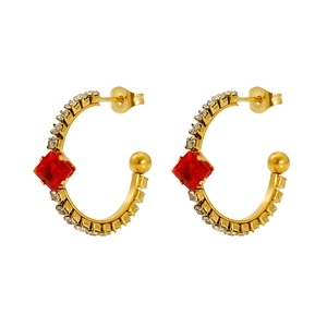 Macro detail of gold vintage earrings featuring red square gems and pave rhinestones