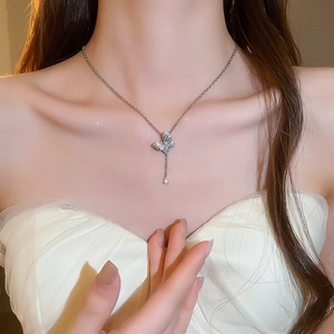 Detail of silver butterfly pendant necklace with sparkling zircons and fringe drop on model