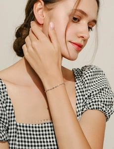 Detail of 925 sterling silver bracelet with multi-colored gemstones on a female wrist