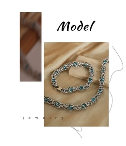 Detailed shot of titanium steel dragon bone chain set with blue beads on silk background