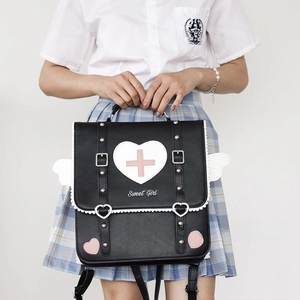 Detailed macro view of black heart-shaped satchel bag with cute wing accents and buckles