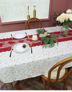 Detail of red Christmas table runner with bells and bows on a festive dining table