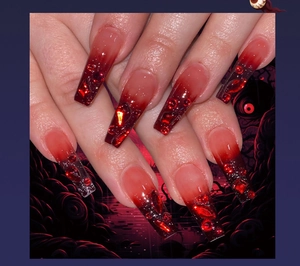 Macro shot of coffin nails with red and black ombre gradients and sparkling rhinestones