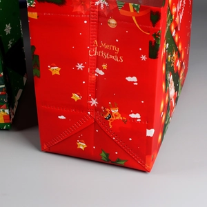 Detail view of red Christmas non-woven gift bag with Merry Christmas text and patterns
