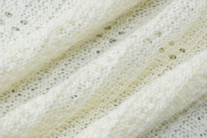 Dettaglio macro della trama del tessuto a maglia bianco con motivo a maglia aperta