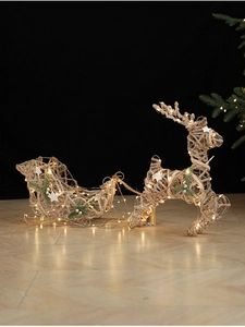 Champagne lighted rattan reindeer and sleigh display with warm LED lights on wood floor