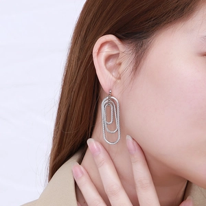 Silver multi-layered geometric spiral earrings shown on a model for a modern look