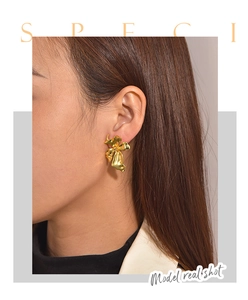 Detail of 18k gold plated textured floral stud earring worn by model with high gloss finish