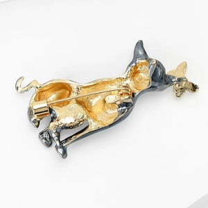 Detail view of animal brooch back showing secure golden pin and rotatable safety clasp