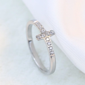 Macro detail of silver stainless steel cross ring with sparkling zircon stones