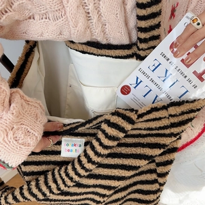 Detail showing plush striped tote bag interior with inner pocket and spacious compartment