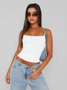 Slim fit white lace camisole top paired with light blue jeans shown on a studio model