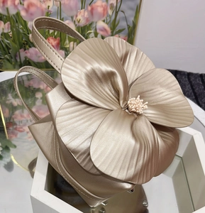 Detailed view of champagne gold floral tote with petal texture and metallic finish