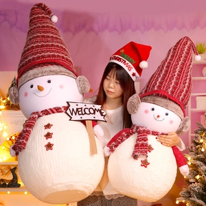 Detail of two plush snowmen with striped hats in a festive holiday home setting