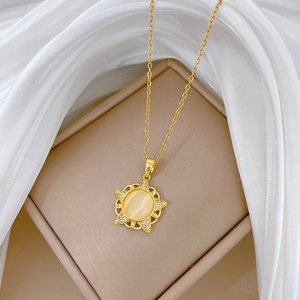 Detailed close-up of a gold starburst pendant featuring cat eye stone and diamonds