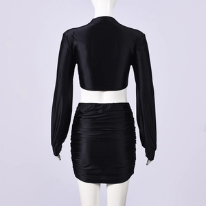Detailed back view of a black long sleeve crop top and ruched bodycon mini skirt set