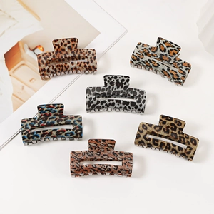 Set of six leopard print acetate hair claws in various colors on a white minimalist background