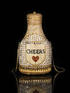Detailed macro of champagne bottle clutch with sparkling crystals and fine gold chain
