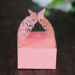 Detailed macro view of laser-cut pink gift box featuring intricate butterfly handle design