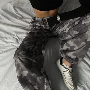 Dettaglio dei pantaloni cargo mimetici grigi con vita elastica e polsini a coste