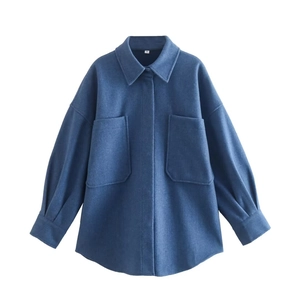 Texture détaillée de la veste chemise en tweed bleu avec poches à rabat à plat