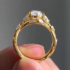 Macro shot of gold leaf vine ring with sparkling round and marquise-cut zircon stones