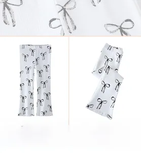 Gros plan sur un tricot côtelé blanc à motifs de nœuds noirs pour leggings enfant