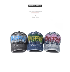 Detailed view of three distressed denim baseball caps with hand-painted graffiti letters