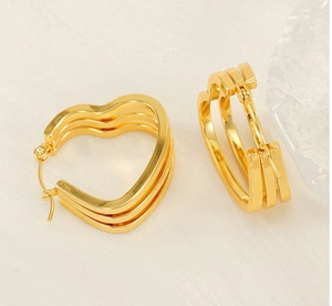 Macro shot of triple-layered golden heart earrings with polished metallic luster