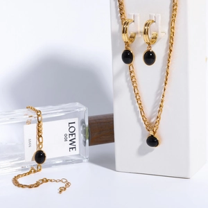 Golden Figaro chain jewelry set with black oval stones including necklace, bracelet and earrings