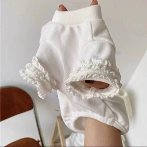 Detail of white cotton dog vest featuring delicate lace edges and soft warm texture