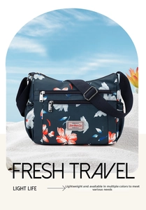 Detail of floral nylon crossbody bag with multiple zip pockets and adjustable strap