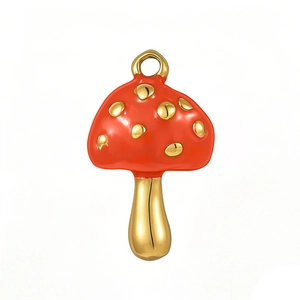 Detailed view of mushroom-shaped metal charm with red enamel and golden spots