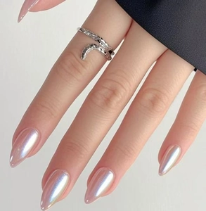 Bague argentée effet serpent portée par un mannequin avec des ongles nacrés irisés