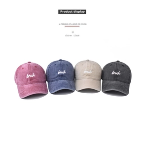 Detail view of four washed cotton baseball caps with bruh embroidery in multiple colors