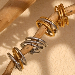 Detail of four-layer intertwined 18K gold and silver rings with cubic zirconia inlay