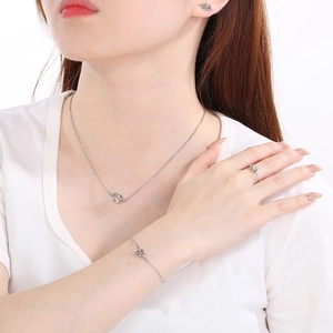 Detailed view of silver knot jewelry set including necklace, bracelet, earrings and ring