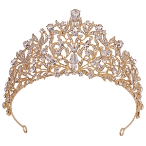 Close-up of golden baroque bridal crown with intricate floral details and red crystals