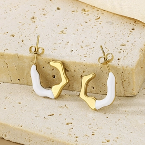Modern C-shape irregular geometric gold earrings with white enamel on beige stone surface