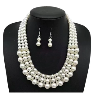 Detailed view of multi-layer pearl necklace set with crystal spacers on a black bust