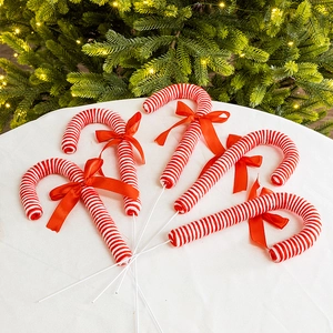 Red and white striped Christmas candy cane ornaments with bows for holiday tree decoration