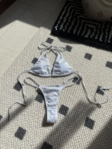Detail of holographic silver bikini set showing the glossy fabric and triangle top ties
