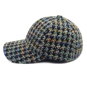 Close-up of colorful fuzzy houndstooth baseball cap with vibrant wool texture and curved brim
