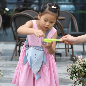 Detailed view of gray shark mesh beach bag worn by a child in an outdoor setting